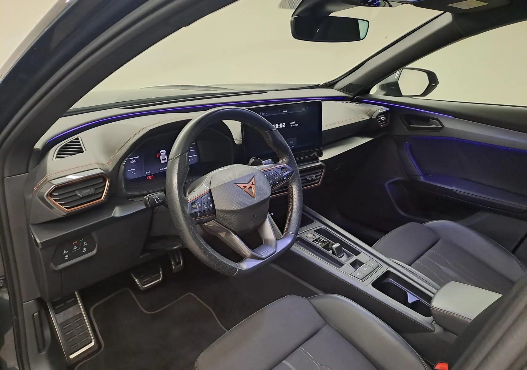 Intérieur avant droit du CUPRA Formentor 1.4 e-HYBRID 245 DSG6 VZ 2024 avec éclairage d’ambiance violet et volant multifonction.