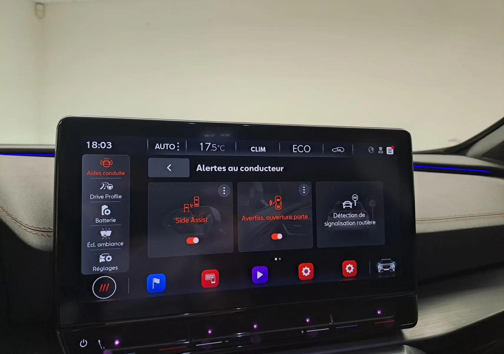 Écran tactile intérieur du CUPRA Formentor 2024 affichant les alertes au conducteur dans un habitacle beige avec éclairage d’ambiance bleu.