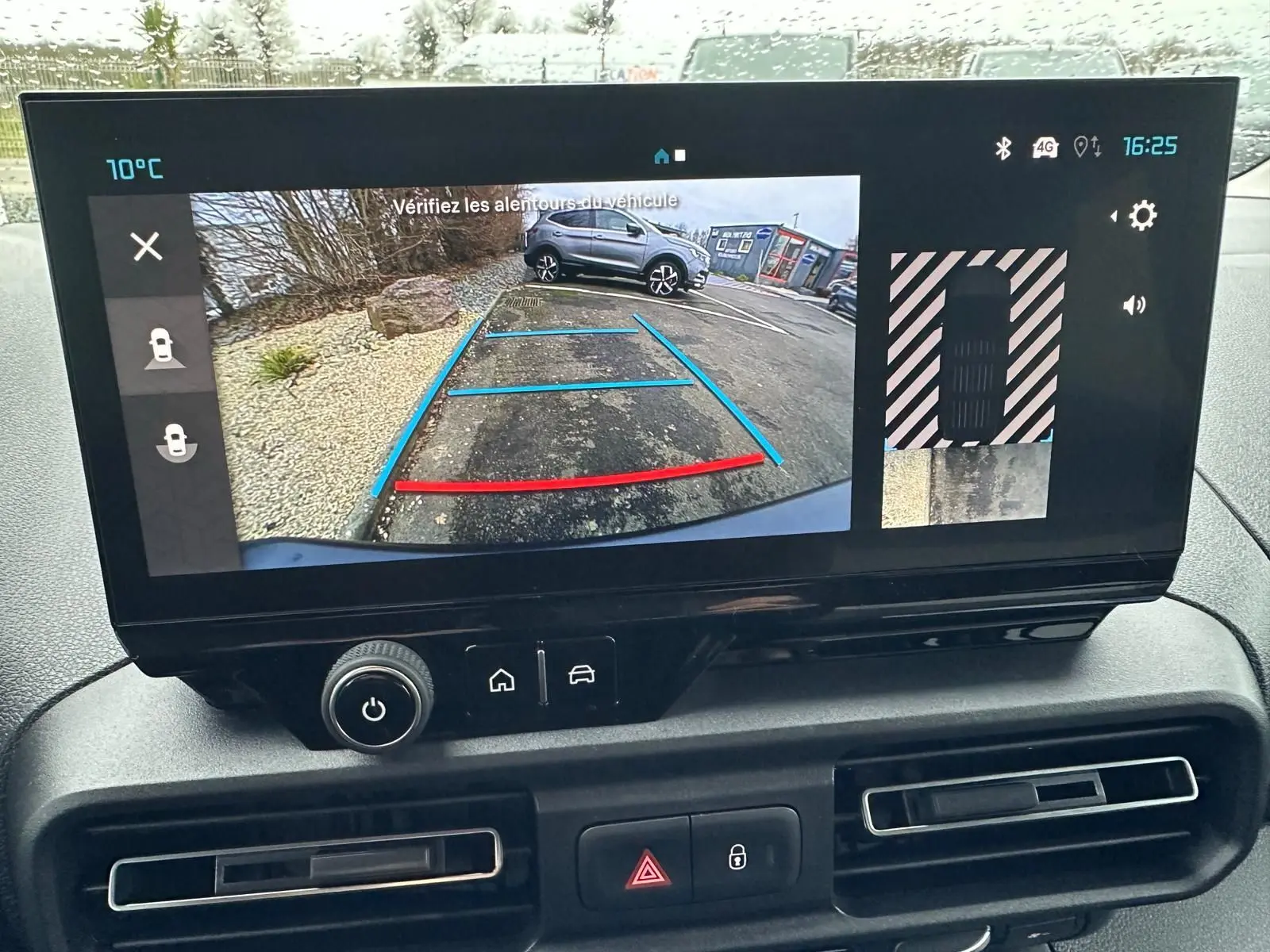 Écran central du Citroën Berlingo 2025 montrant la caméra de recul avec lignes de guidage en bleu et rouge.