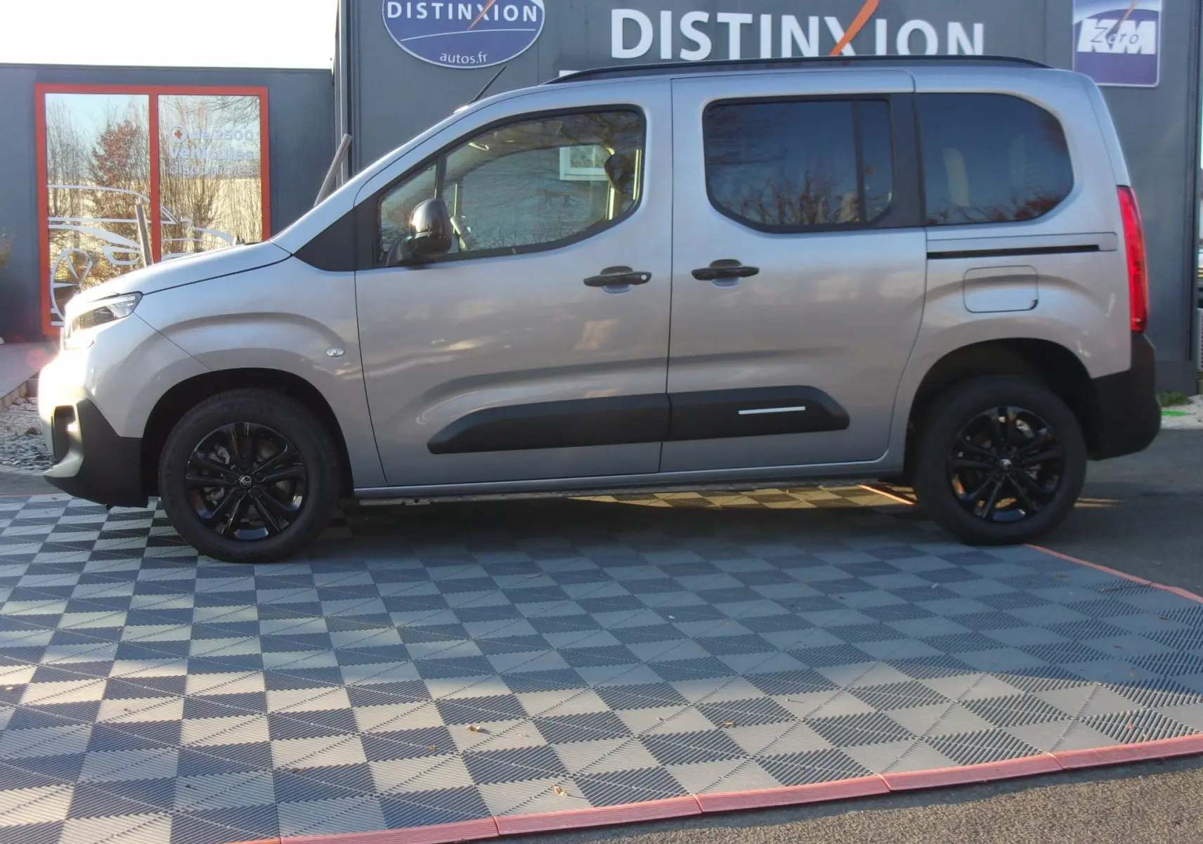 Vue latérale droite d'un Citroën Berlingo gris Artense 2025 avec jantes noires et protections latérales noires.