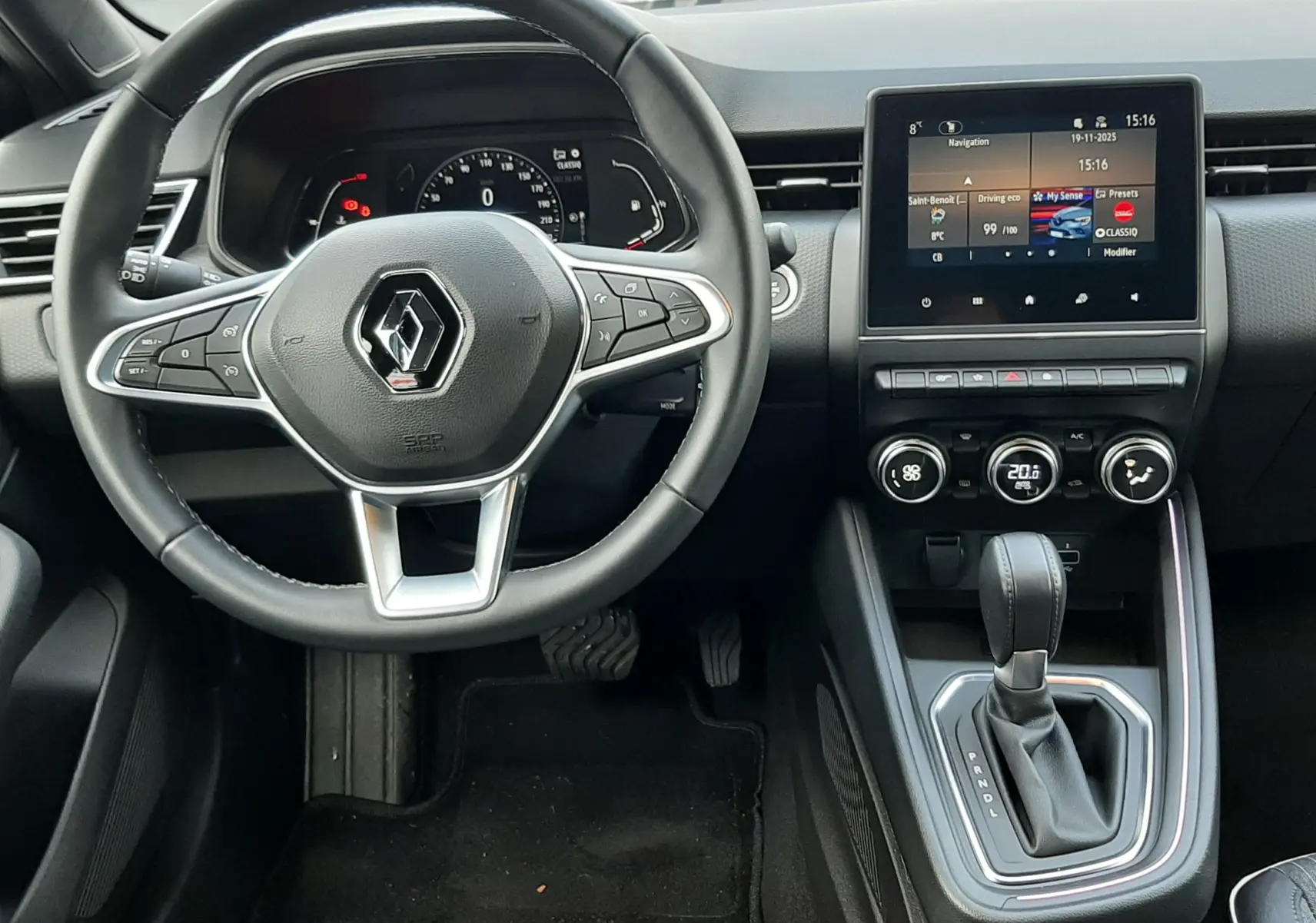 Vue intérieure du poste de conduite de la Renault Clio V TCE 90 Intens, tableau de bord moderne avec écran tactile et volant multifonction.
