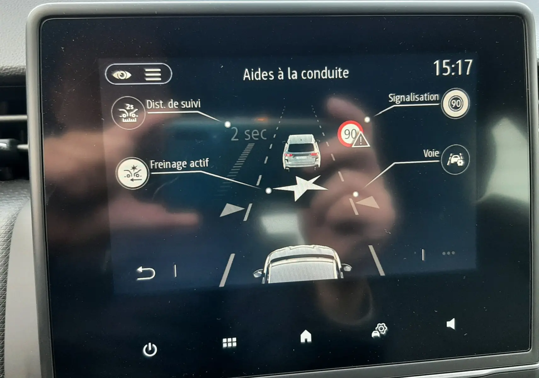 Écran tactile du système d’aides à la conduite de la Renault Clio V gris titanium, affichant freinage actif et signalisation.