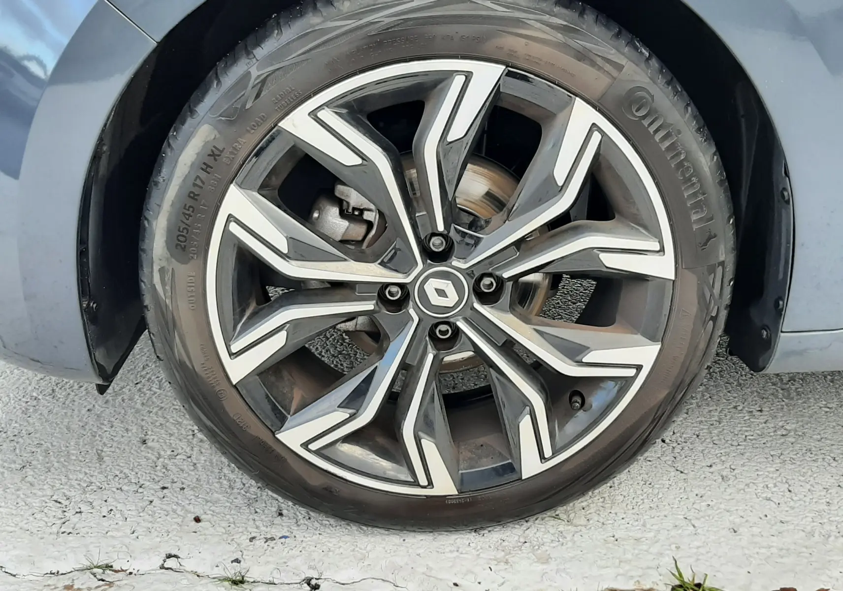 Gros plan sur la roue avant gauche gris titanium d'une Renault Clio V TCE 90 Intens X-Tronic avec jante alliage bicolore.