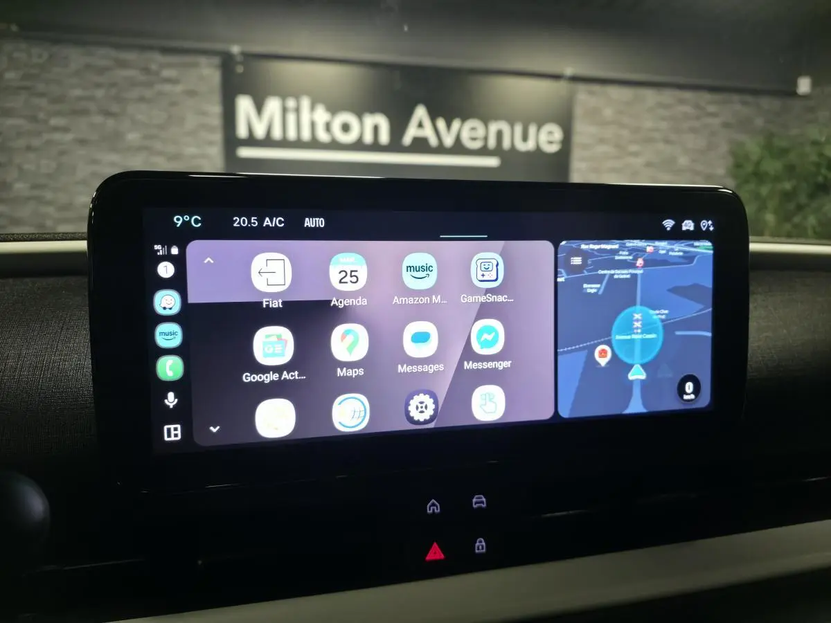 Écran tactile central du tableau de bord de la Fiat 600 rouge, affichant navigation et applications connectées.