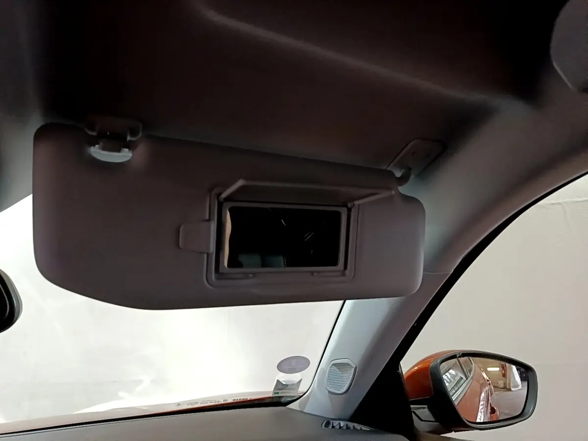 Vue intérieure côté conducteur du pare-soleil avec miroir intégré sur Peugeot 2008 orange, version 2021.