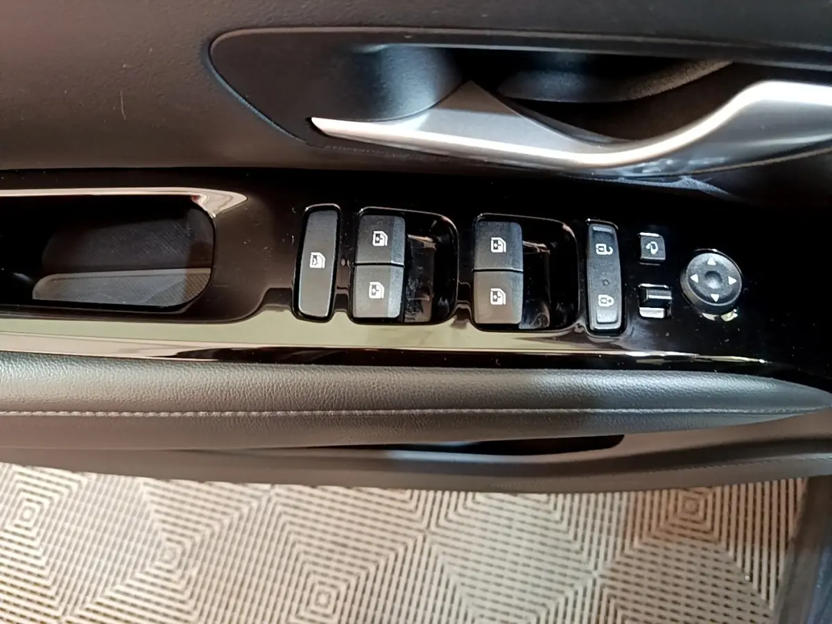 Gros plan sur la commande des vitres et rétroviseurs côté conducteur du Hyundai Tucson bleu 2023.