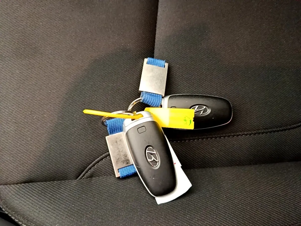 Gros plan sur deux clés Hyundai noires posées sur un siège en tissu noir à l'intérieur du véhicule.