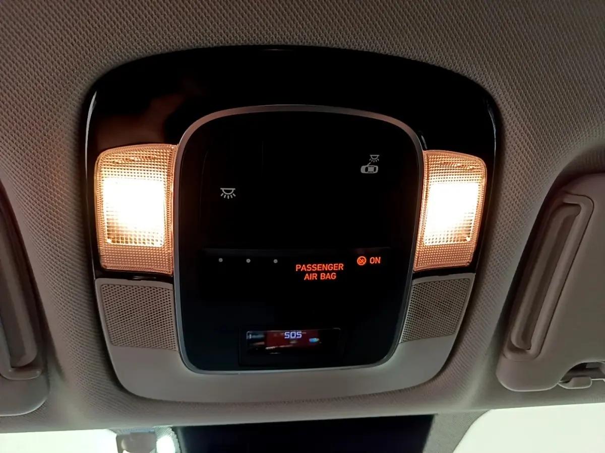 Plafonnier intérieur avec éclairage allumé et affichage de l'airbag passager activé dans un Hyundai Tucson bleu 2023.
