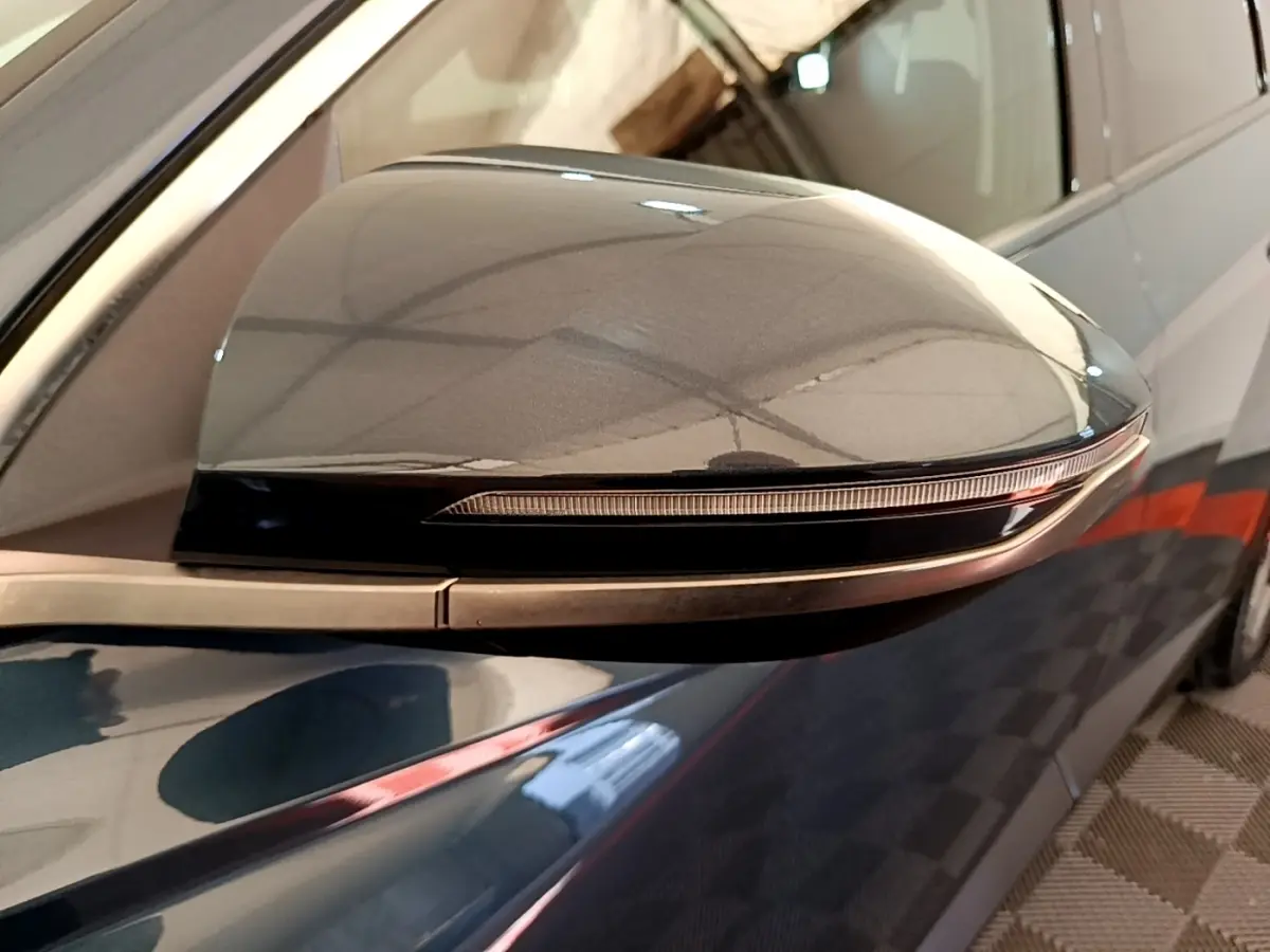 Rétroviseur côté droit bleu du Hyundai Tucson 2023 avec clignotant intégré, vue rapprochée en extérieur.