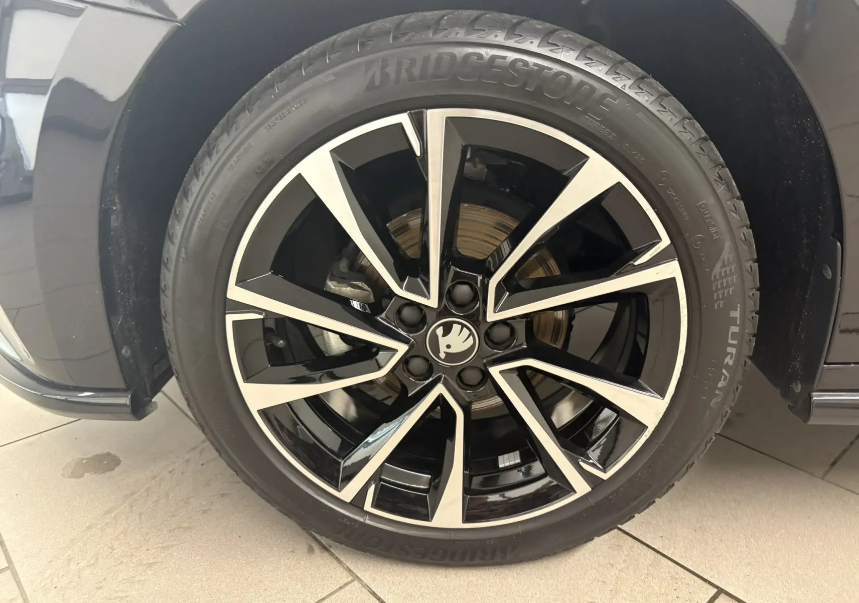 Gros plan sur la roue avant gauche de la Skoda Fabia 2025 Monte Carlo en Noir Magic nacré avec jante alliage bicolore.