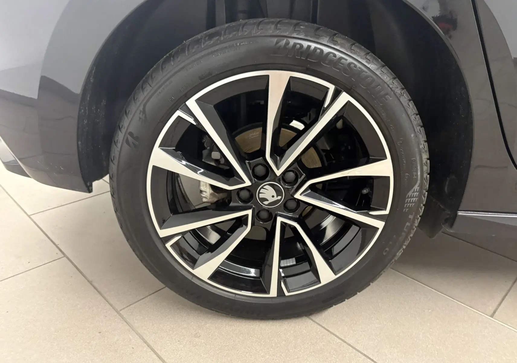 Gros plan sur la roue avant droite de la Skoda Fabia 2025 Noir Magic nacré avec jante alliage noire et argentée Monte Carlo.
