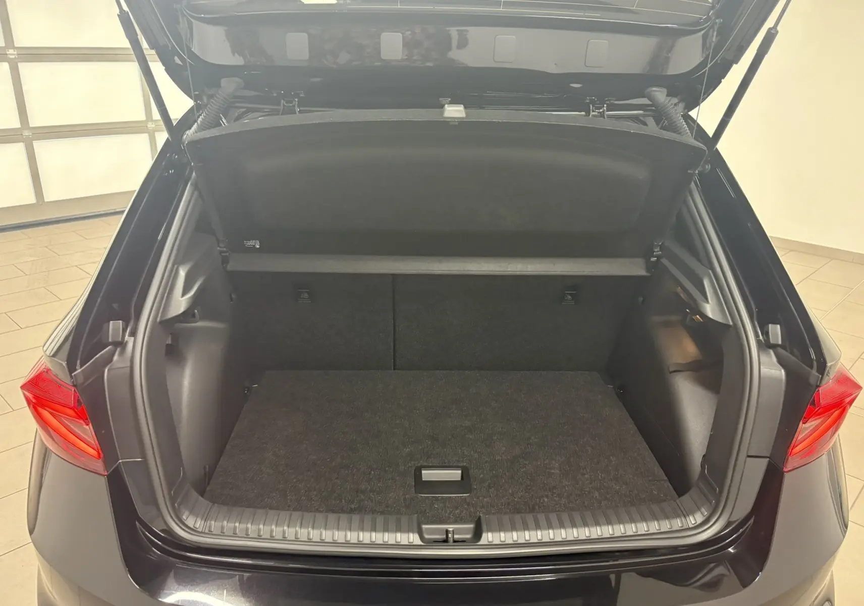 Coffre ouvert vu de l'arrière d'une Skoda Fabia 2025 Noir Magic Nacré avec double plancher variable visible.