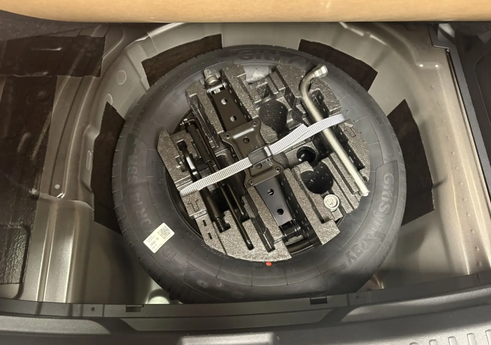 Vue plongeante sur la roue de secours et le double plancher variable dans le coffre de la Skoda Fabia Noir Magic nacré.