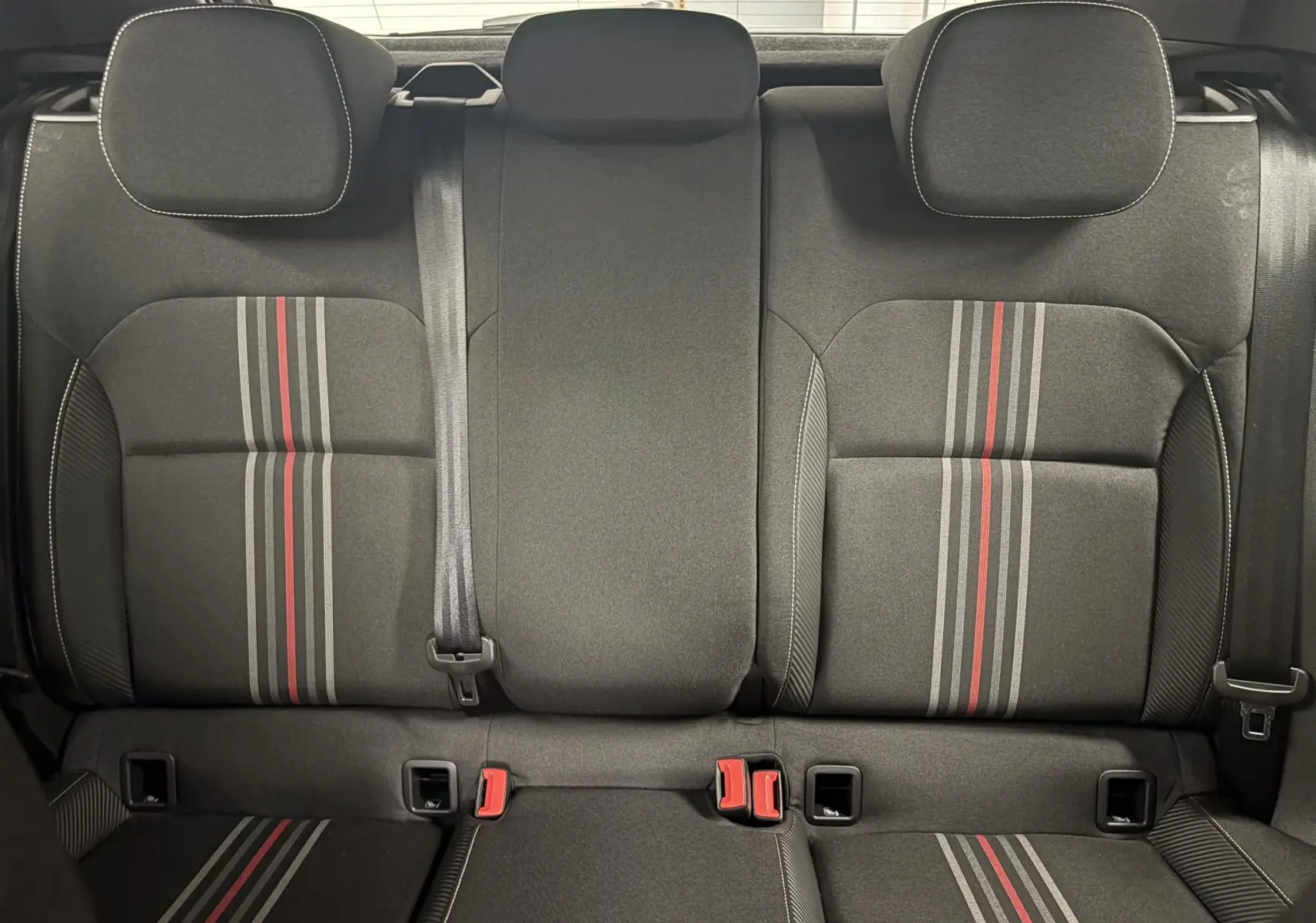 Vue intérieure arrière des sièges noirs avec bandes grises et rouges, Skoda Fabia Monte Carlo 2025.