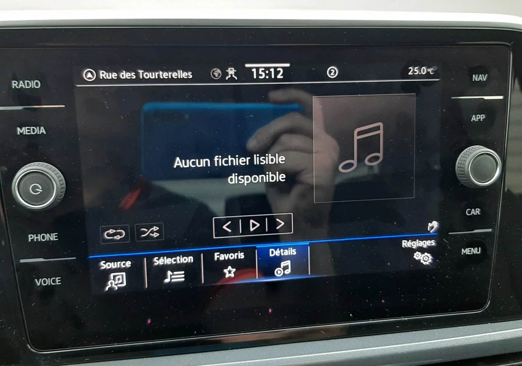 Vue rapprochée de l’écran multimédia du Volkswagen T-Roc blanc toit noir, affichant un message « Aucun fichier lisible disponible ».