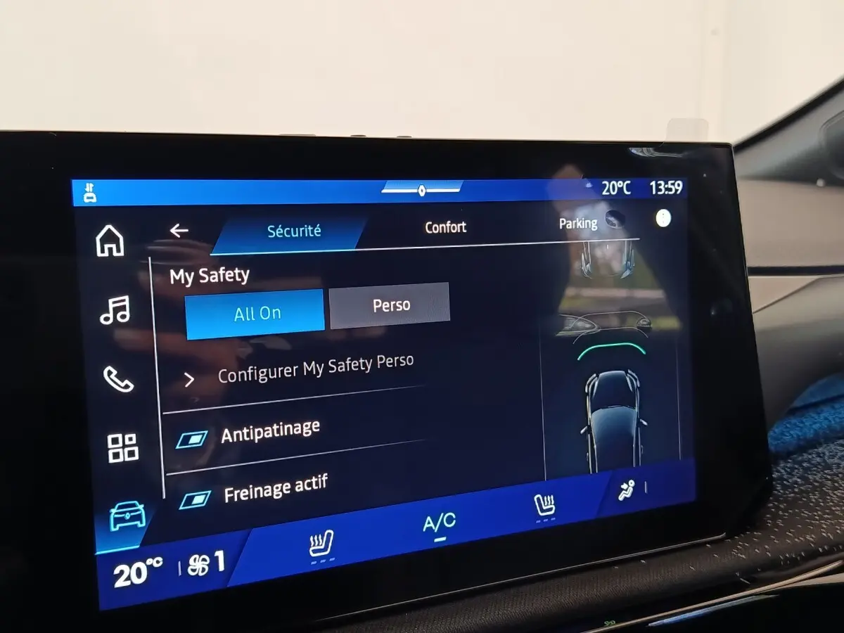 Écran tactile central de la Renault Clio Techno gris foncé, affichant les réglages de sécurité et confort.