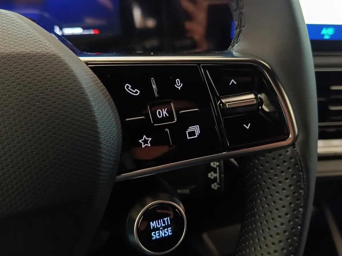 Gros plan sur les commandes multifonctions du volant perforé de la Renault Clio Techno gris foncé 2026.