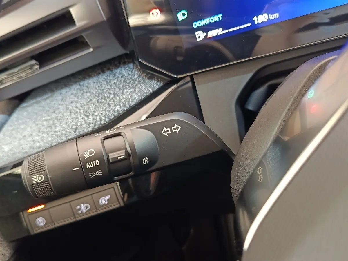 Gros plan sur la commande des clignotants et phares dans l’habitacle de la Renault Clio Techno TCe 115 2026.
