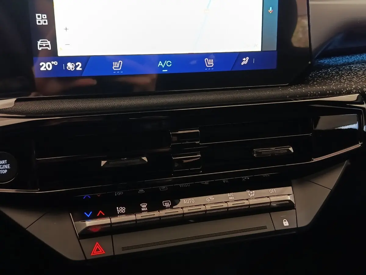 Détail du tableau de bord central de la Renault Clio Techno TCe 115 gris foncé avec écran tactile et commandes climatisation.