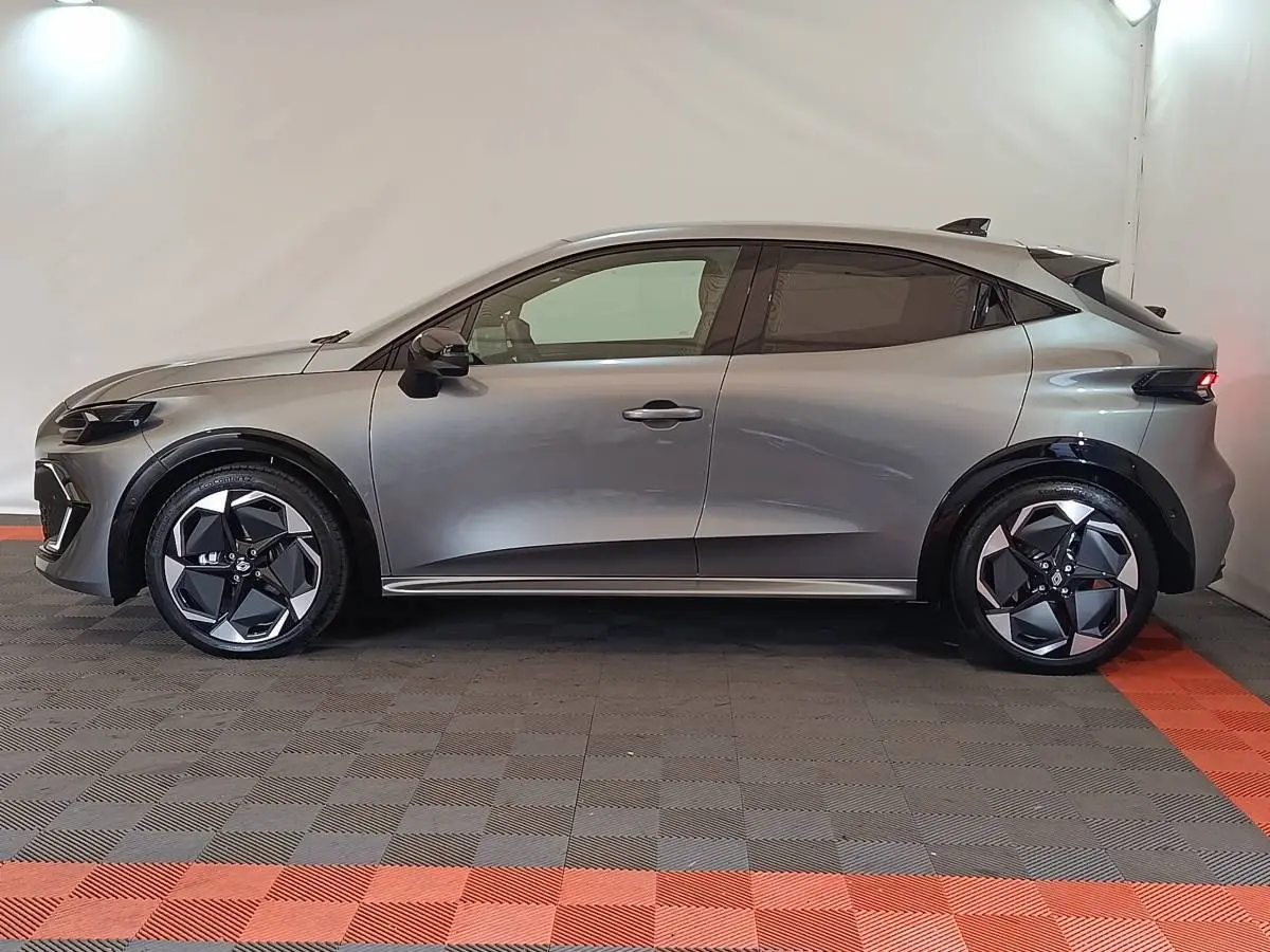 Profil droit de la Renault Clio 2026 gris foncé avec jantes noires et détails de carrosserie modernes.
