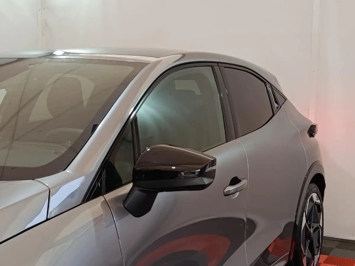 Vue de profil côté gauche sur une Renault Clio Techno TCe 115 essence gris foncé avec rétroviseur noir brillant.