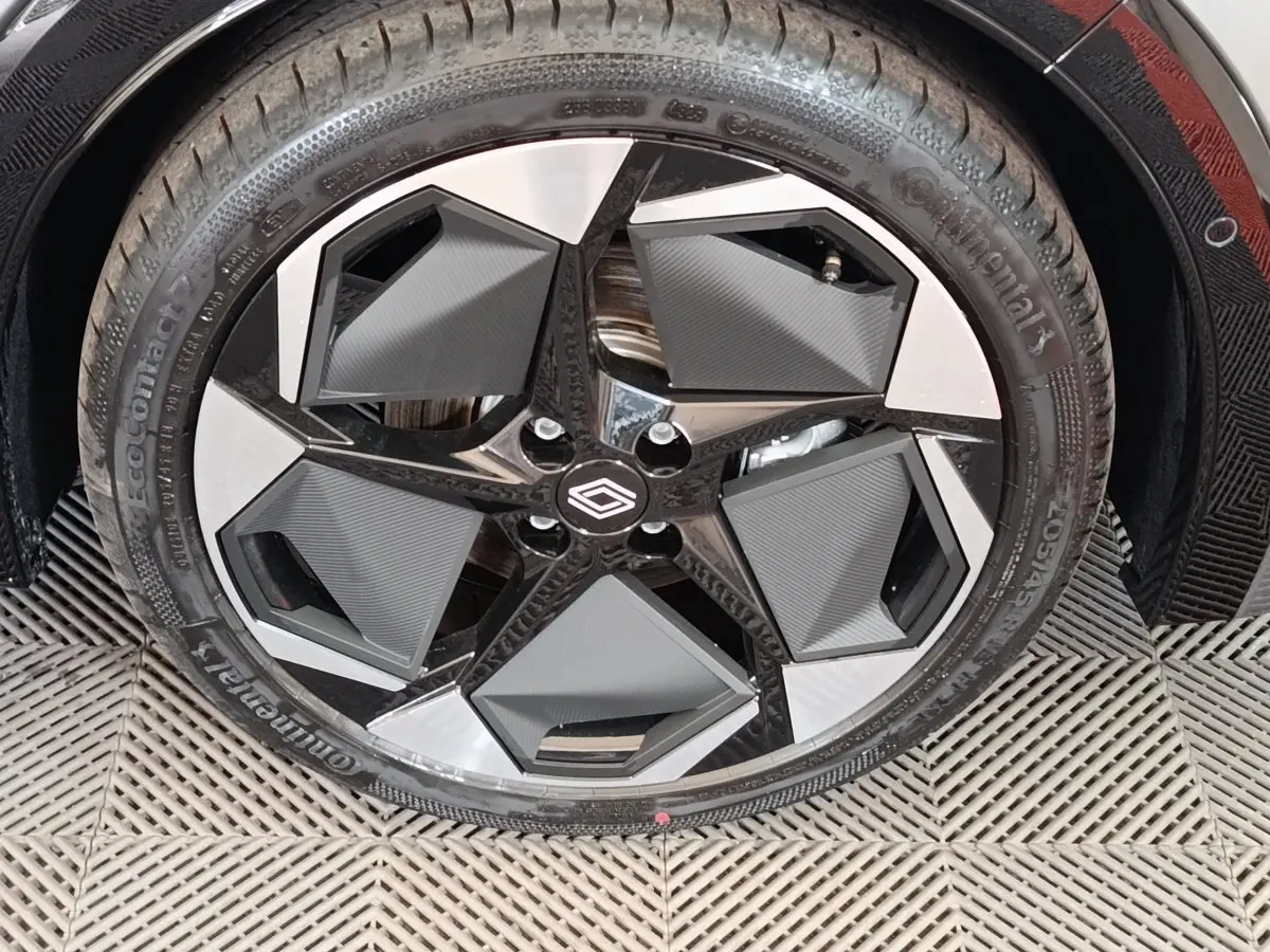 Gros plan sur la jante avant droite de la Renault Clio gris foncé, avec un design moderne et pneus Continental.