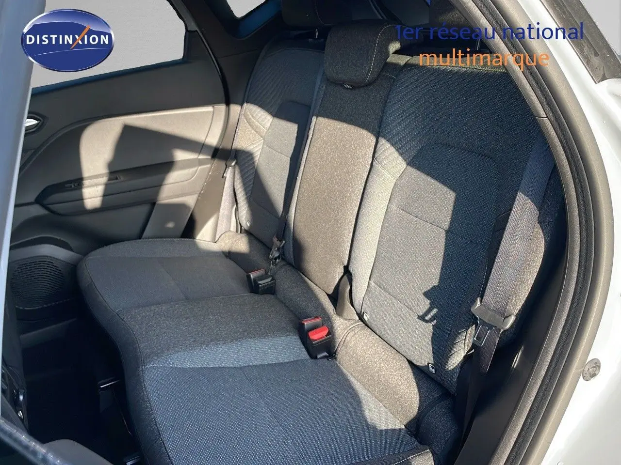 Vue intérieure sur les sièges arrière en tissu gris du Renault Captur E-Tech 2025, porte arrière ouverte côté droit.