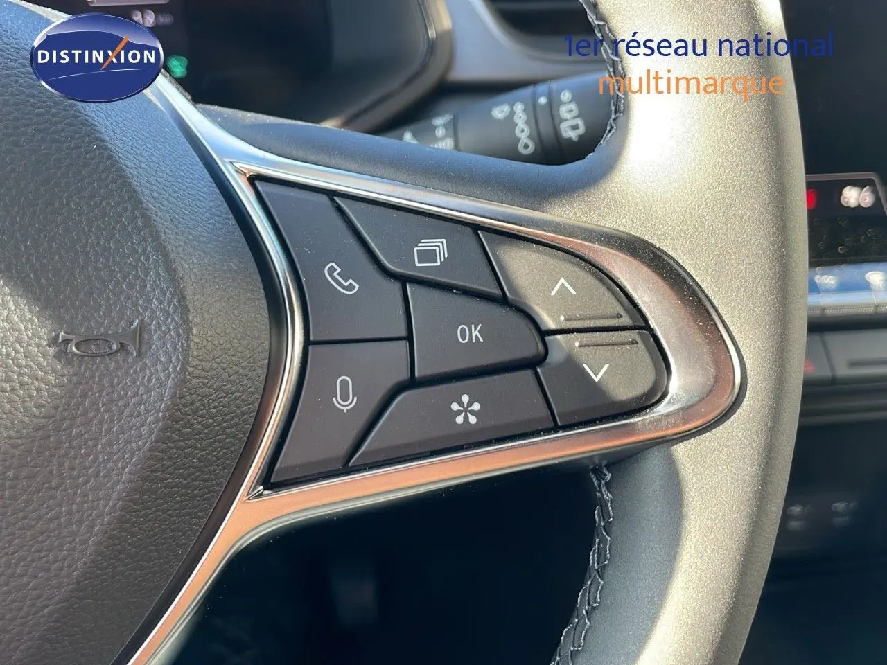 Gros plan sur les commandes multifonctions au volant du Renault Captur E-Tech hybride gris rafale avec finition noire.