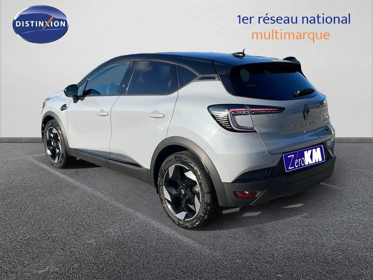 Vue 3/4 arrière droite du Renault Captur E-Tech hybride gris Rafale avec toit noir et jantes noires brillantes.