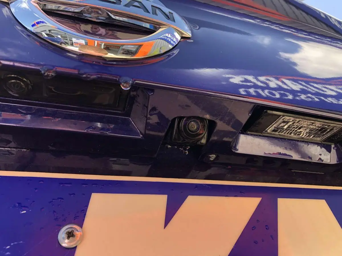 Gros plan sur la caméra de recul intégrée au hayon bleu métallisé du Nissan Qashqai 2019.