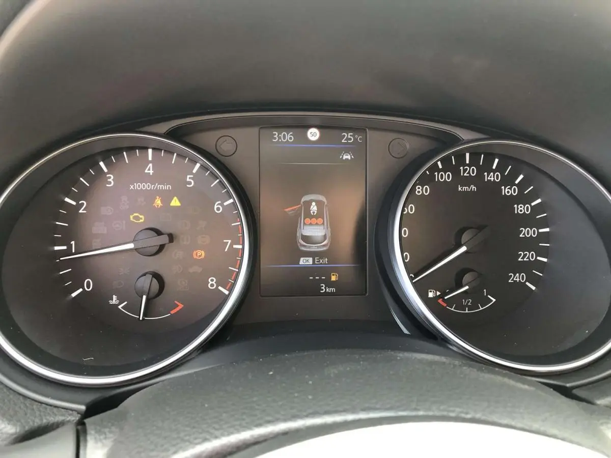 Vue rapprochée du tableau de bord du Nissan Qashqai bleu, affichant compte-tours, vitesse et écran central numérique.