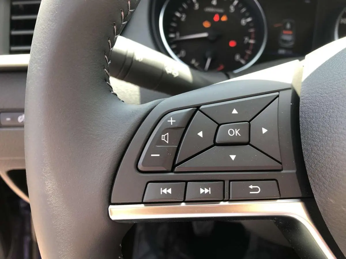 Gros plan sur les commandes multifonctions du volant noir du Nissan Qashqai 2019, version 1.3 DIG-T N-Connecta.