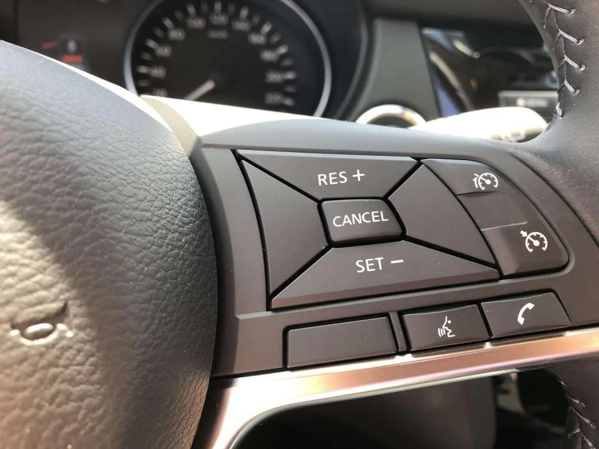 Gros plan sur les commandes du régulateur de vitesse au volant noir du Nissan Qashqai 1.3 DIG-T 2019.
