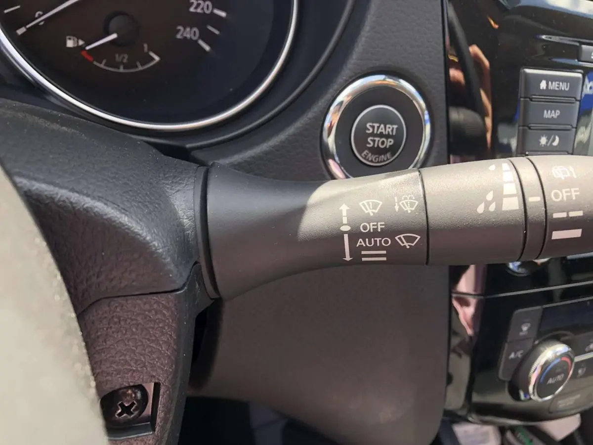 Gros plan sur la commande d'essuie-glace et le bouton Start/Stop du tableau de bord noir du Nissan Qashqai bleu 2019.