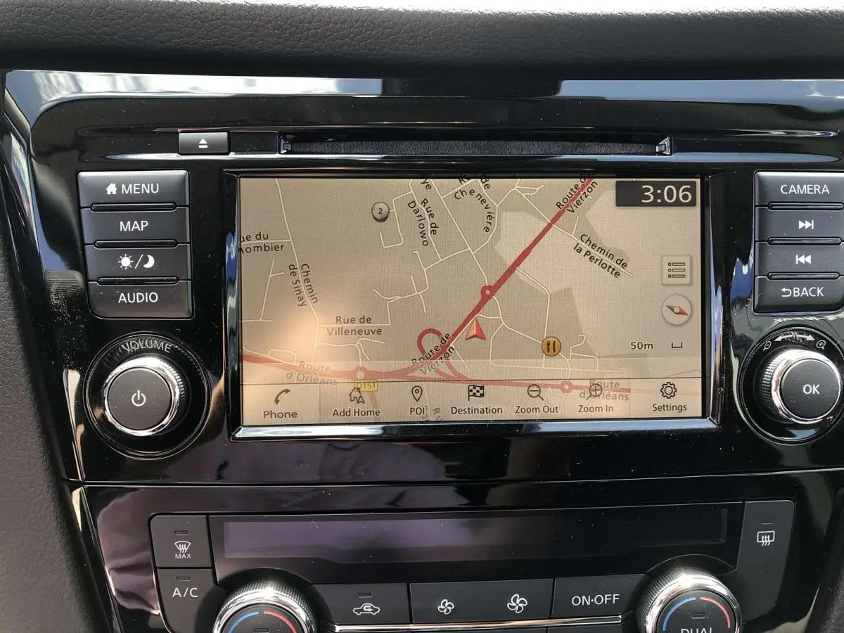Écran tactile central du Nissan Qashqai bleu 2019 montrant la navigation GPS avec commandes autour.