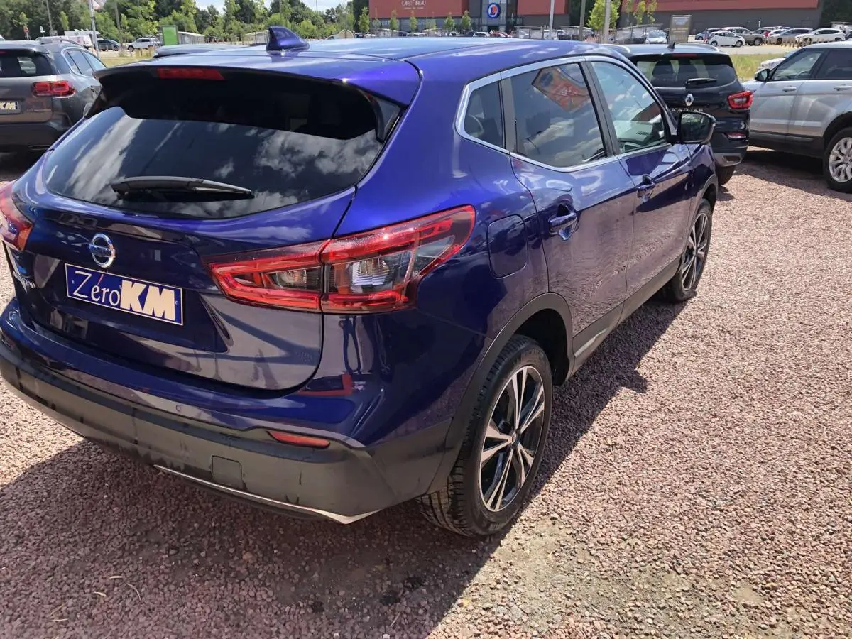 Vue 3/4 arrière droite d'un Nissan Qashqai bleu métallisé avec jantes alliage et feux arrière LED distinctifs.