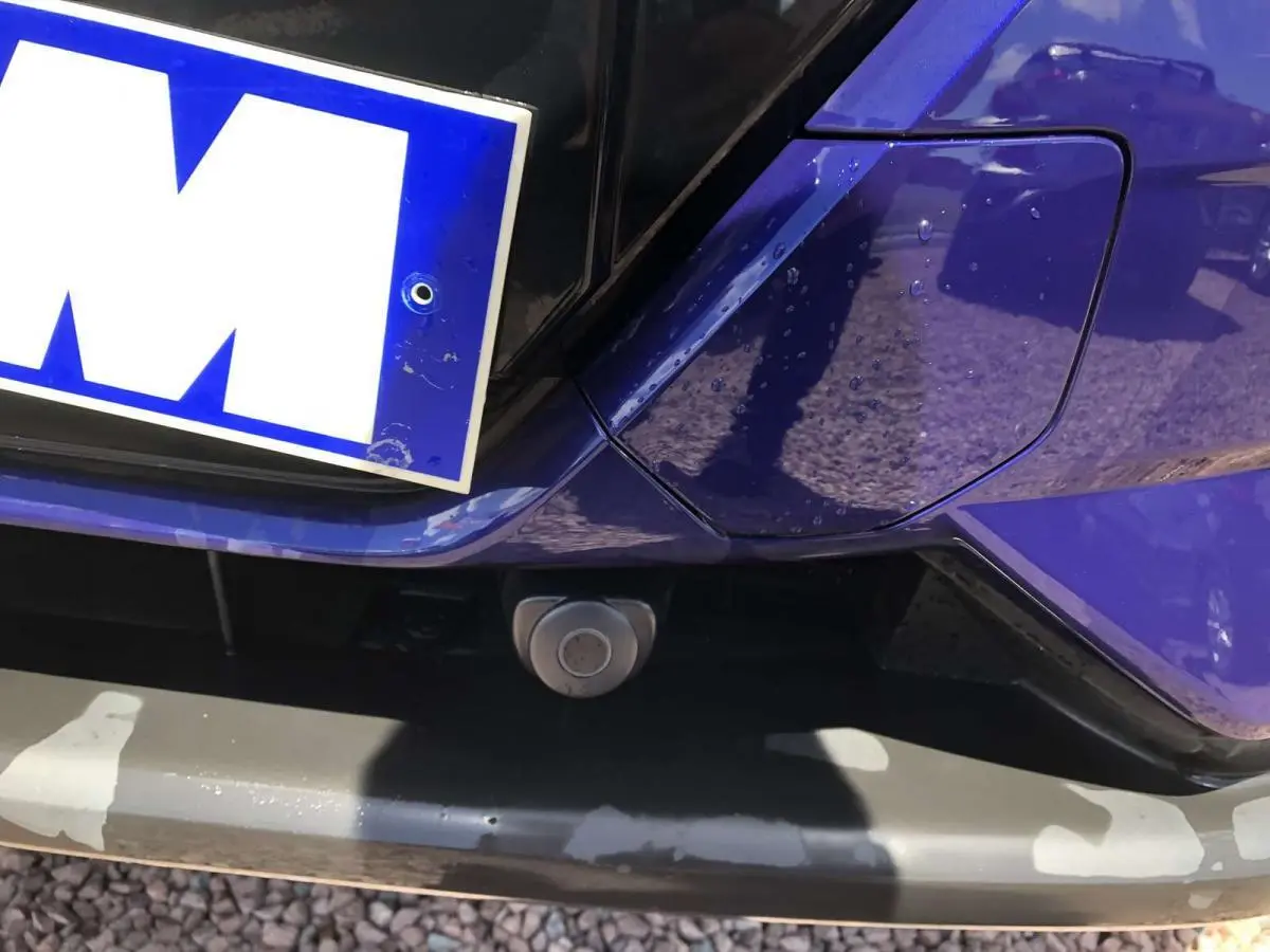 Gros plan sur l'arrière bleu métallisé du Nissan Qashqai 2019, mettant en valeur la caméra de recul sous la plaque.