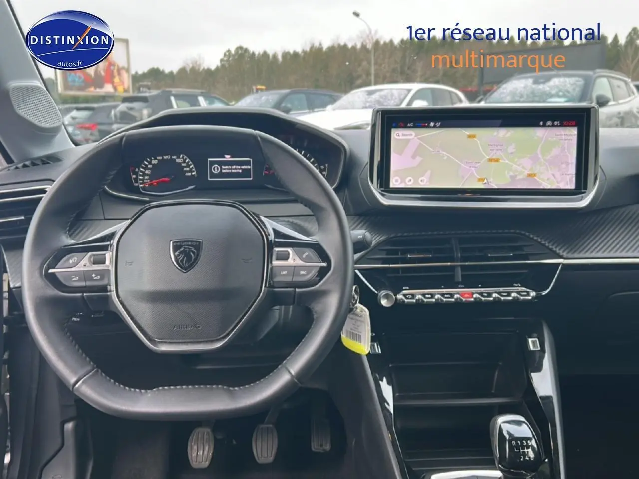 Intérieur Peugeot 208 2025 vue du poste de conduite avec volant compact, écran tactile et levier de vitesses manuel.