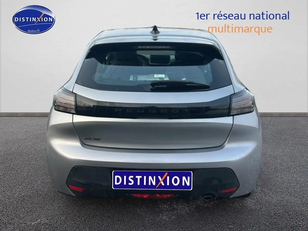 Vue arrière d'une Peugeot 208 gris Artense avec feux arrière sombres et logo Peugeot central noir.