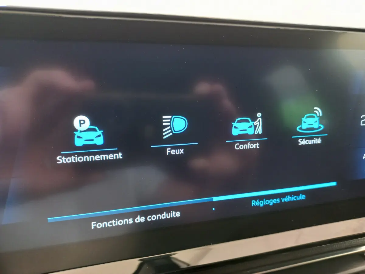 Écran tactile intérieur du Peugeot 5008 gris foncé, affichant les options de conduite et sécurité.