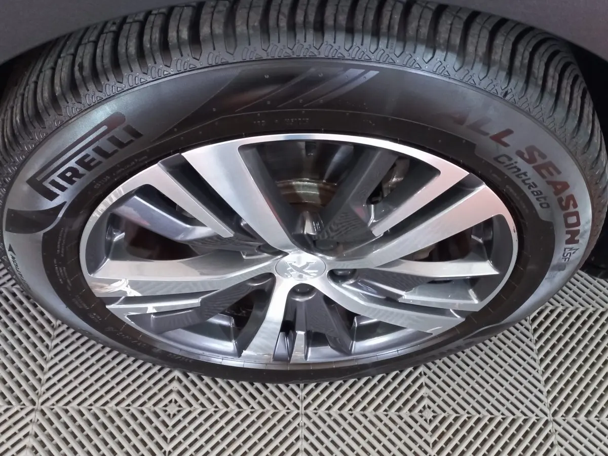 Gros plan sur la jante alliage et pneu Pirelli All Season du Peugeot 5008 gris foncé, détail de la roue avant.
