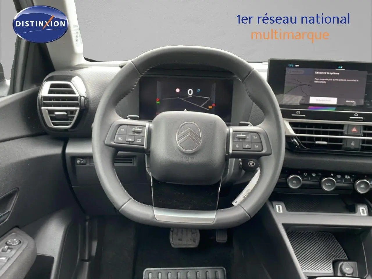 Vue frontale de l'intérieur du Citroën C4 blanc métal, avec volant multifonction et tableau de bord numérique.