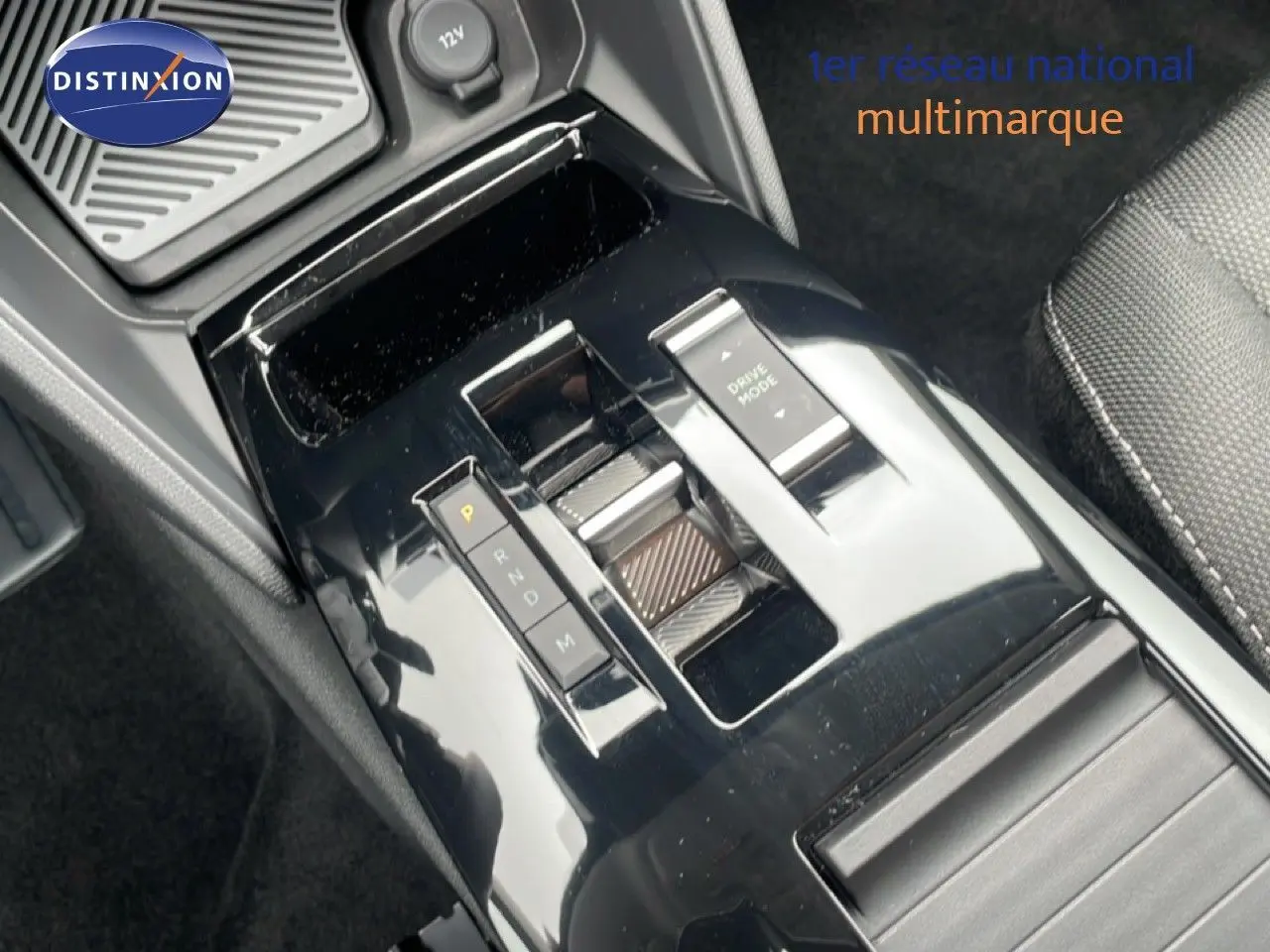Gros plan sur la console centrale noire brillante de la Citroën C4 blanche, avec levier de vitesses automatique et bouton Drive Mode.