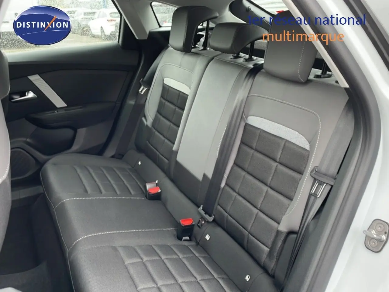 Vue intérieure côté arrière droit montrant les sièges arrière en tissu noir avec détails gris d'une Citroën C4 blanc métal.
