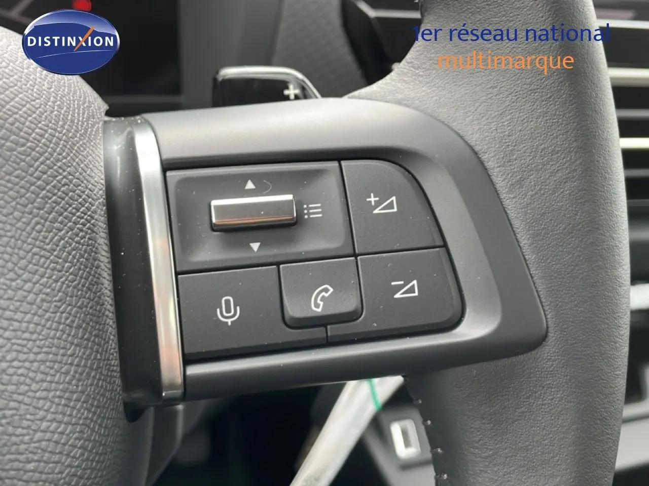 Gros plan sur les commandes au volant en cuir noir du Citroën C4 blanc métal, version PureTech 130ch EAT8 Plus.