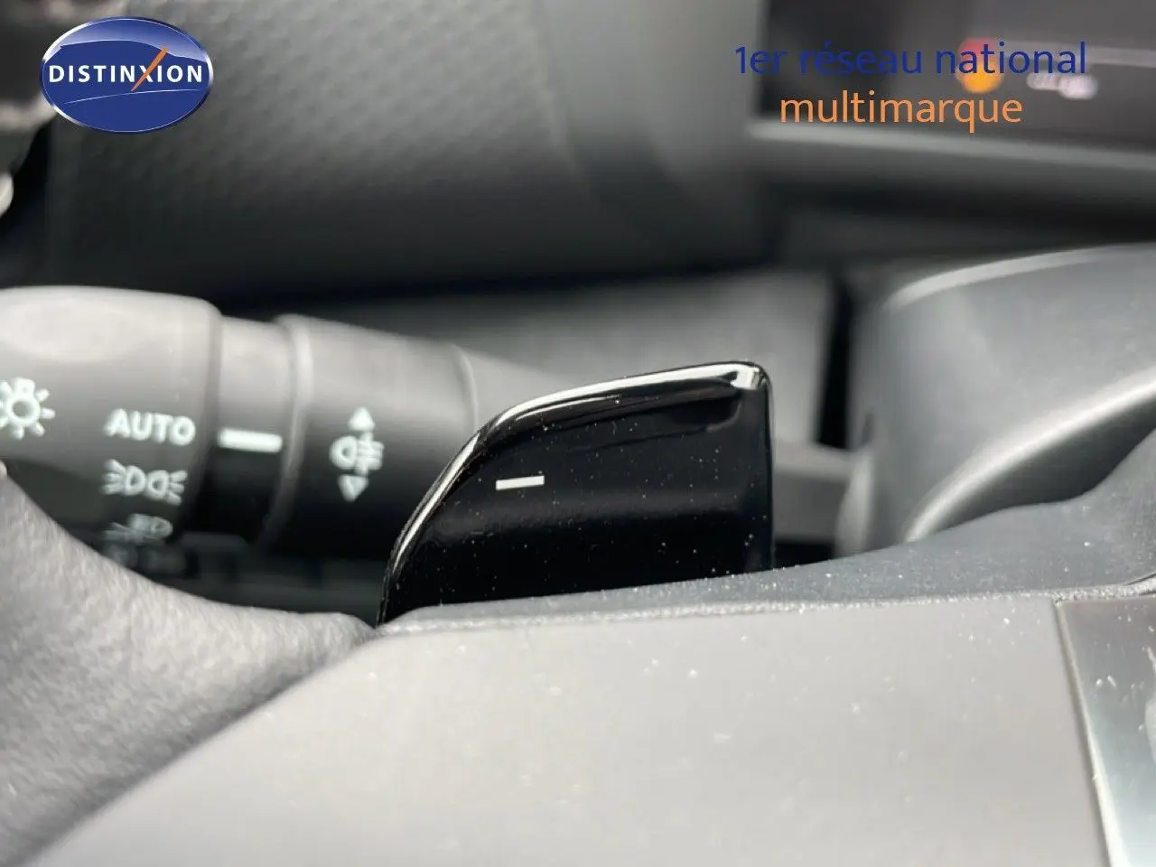 Gros plan sur la palette de changement de vitesse noire côté droit du volant d'une Citroën C4 blanche.
