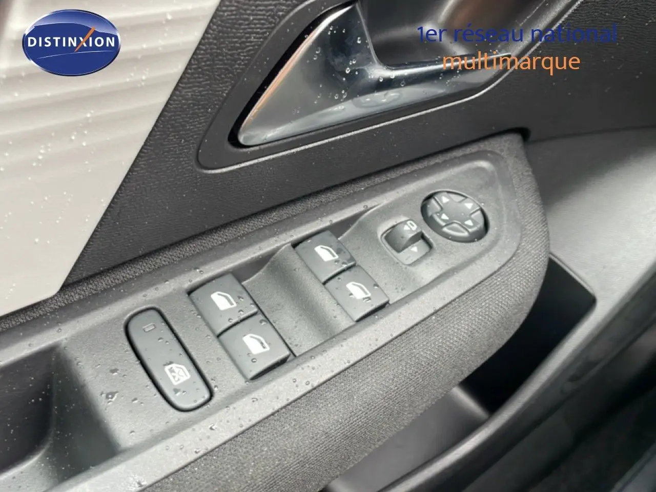 Gros plan sur les commandes des vitres et rétroviseurs côté gauche d’une Citroën C4 blanc métal.