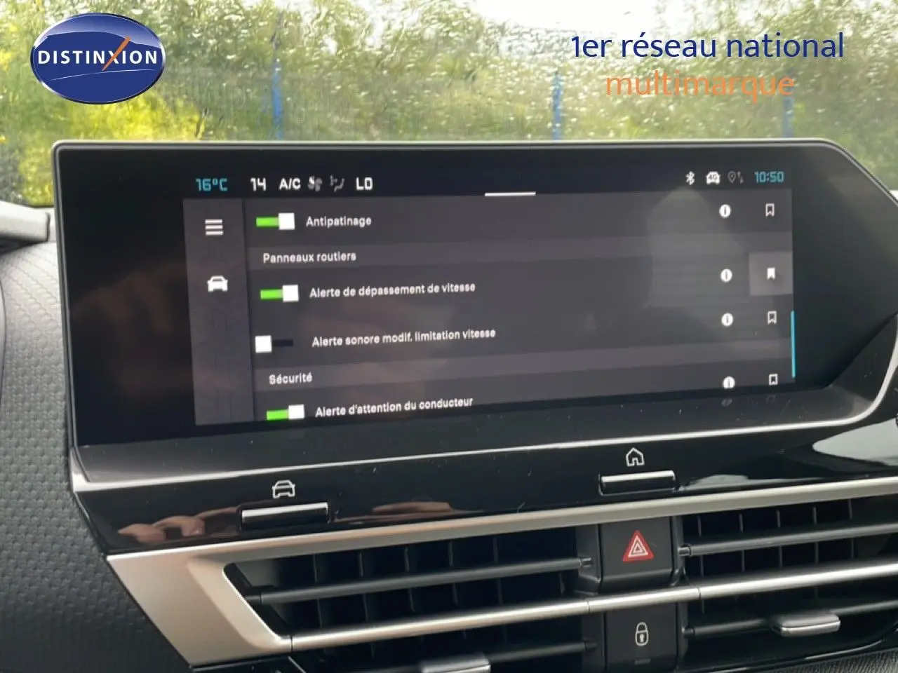 Vue intérieure du tableau de bord de la Citroën C4 blanc métal, écran tactile affichant les aides à la conduite.