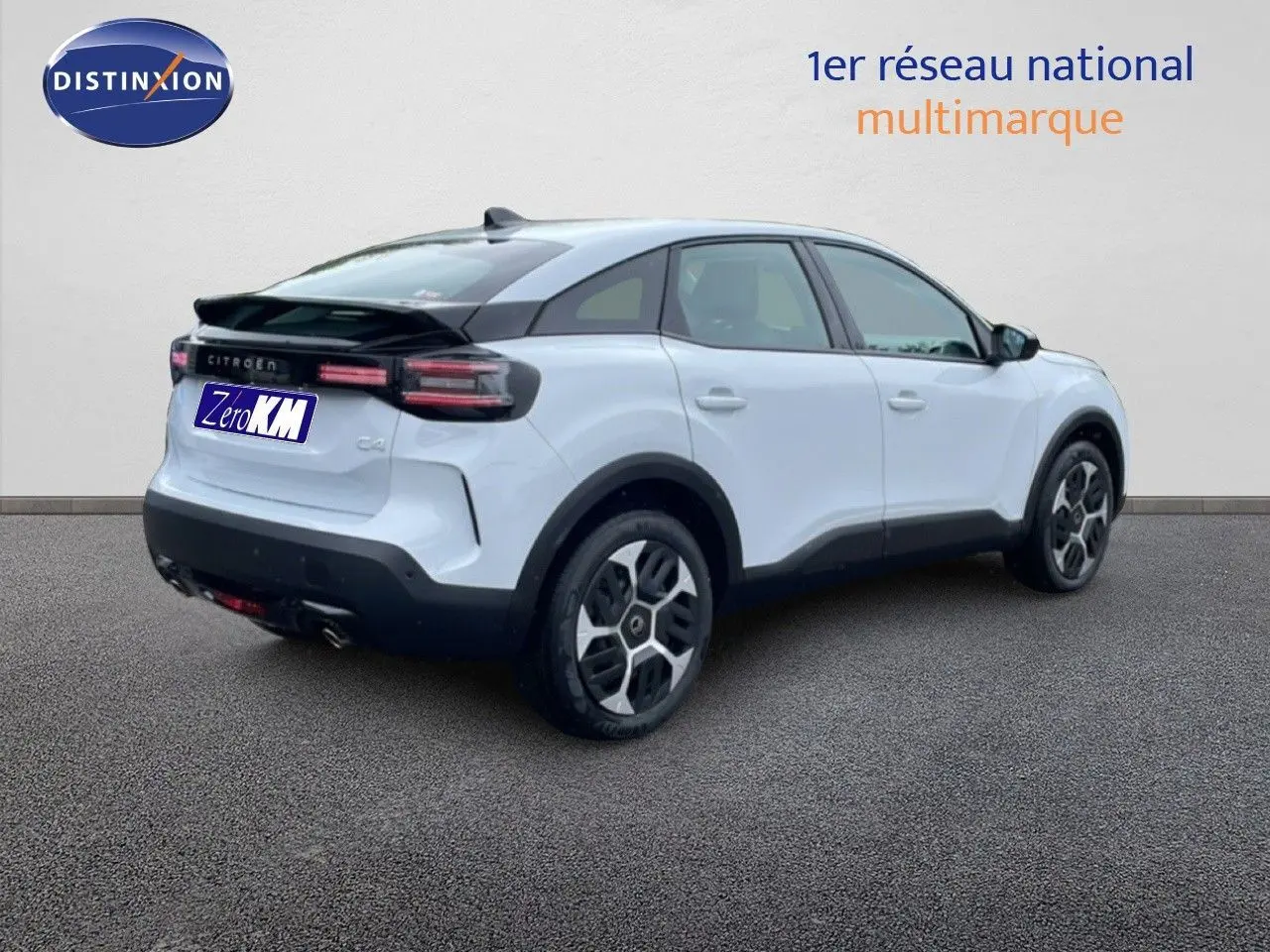 Vue 3/4 arrière droite d'une Citroën C4 blanc métal avec toit noir et feux arrière LED distinctifs.