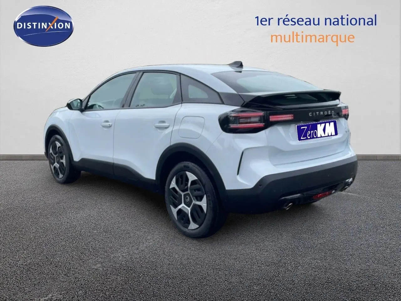 Vue 3/4 arrière droite d'une Citroën C4 blanc métal avec toit noir et feux arrière LED distinctifs.